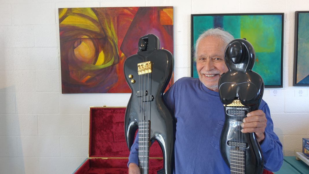 Nick Hernandez of Laguna Beach with two of his standout pieces “Goddess Guitar” and “Inner-vision Bass Guitar” at Woods Cove Art Studio & Gallery on July 27. Photo by Daniel Langhorne